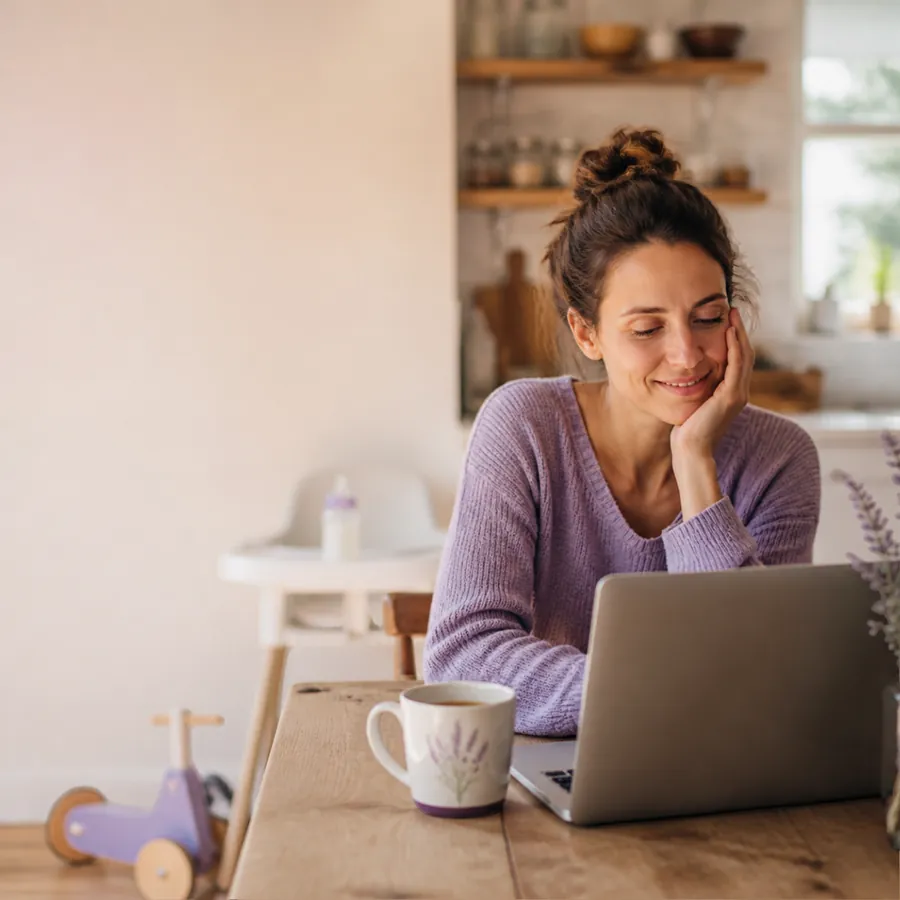 Mum working on a laptop at home with a cup of tea